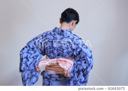 Back view of a woman wearing an indigo-dyed yukata, obi tie 92683075