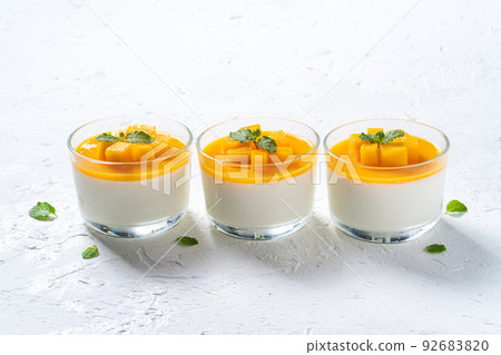 Delicious double colored mango panna cotta mousse pudding on white table background. 92683820