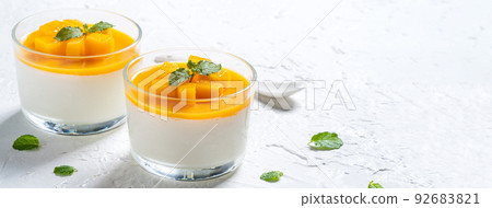 Delicious double colored mango panna cotta mousse pudding on white table background. 92683821