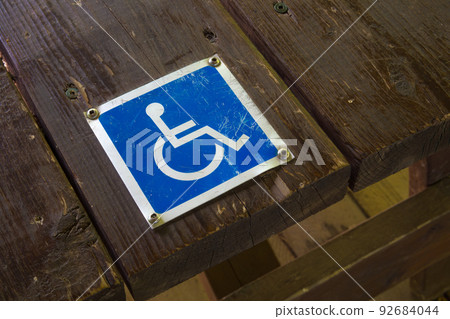 handicap sign wheelchair accessibility metal blue pictogram on wood 92684044