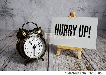 Hurry up! text message and alarm clock on wooden background Hurry up! text message and alarm clock on wooden background 92685050