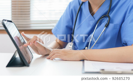 Pet care concept, Female veterinary using tablet for relaxation after examining health pet 92685270