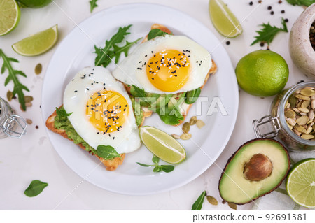 healthy breakfast or snack - sliced avocado and fried egg on toasted bread healthy breakfast or snack - sliced avocado and fried egg on toasted bread 92691381