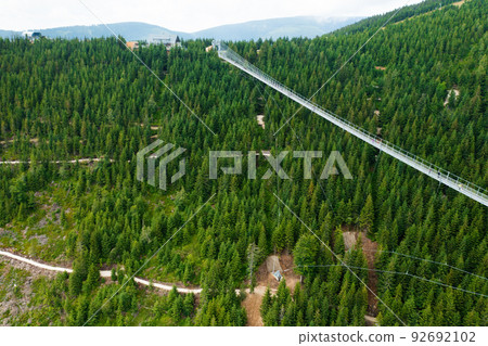 Sky Bridge 721 is the longest suspension bridge between two hills in the forest, Dolni Morava, Czech Republic . One way footbridge in touristic place in the forest in summer.  92692102