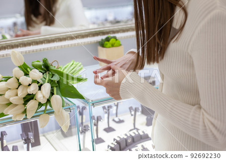 girl trying on a ring in a jewelry store 92692230