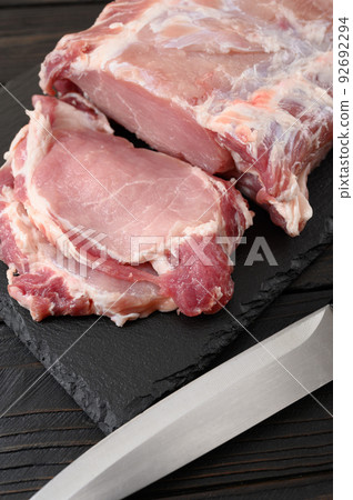A large piece of pork loin on a rustic dark background. A large piece of pork loin on a rustic dark background. 92692294