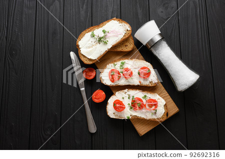 Toasts with microgreens on the table. Healthy food, vegan food and dieting concept. Toasts with microgreens on the table. Healthy food, vegan food and dieting concept. 92692316