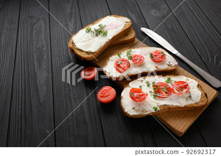 Toasts with microgreens on the table. Healthy food, vegan food and dieting concept. Toasts with microgreens on the table. Healthy food, vegan food and dieting concept. 92692317