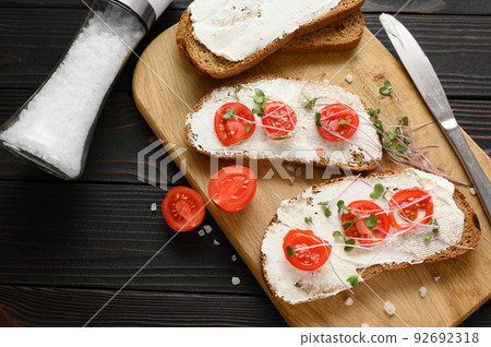 Toasts with microgreens on the table. Healthy food, vegan food and dieting concept. Toasts with microgreens on the table. Healthy food, vegan food and dieting concept. 92692318