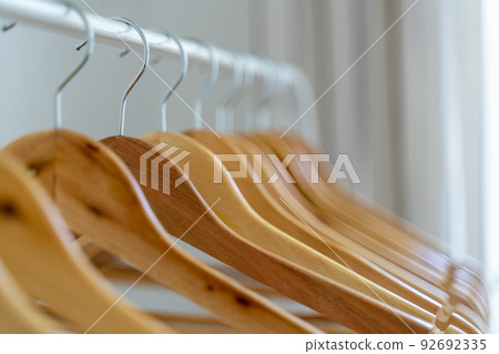 Close-up of wardrobe with wooden clothes hanger, 92692335