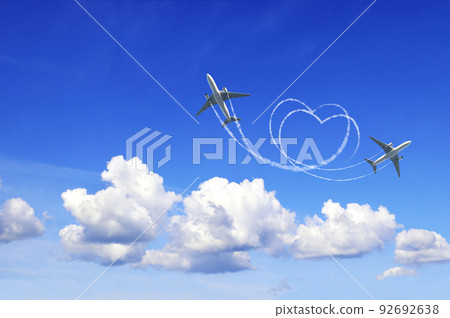 Horizontal nature background with two aircrafts draw a heart in the sky. Flight route of aircraft in shape of a heart 92692638