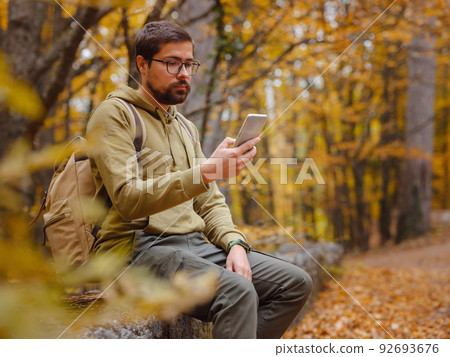 Young handsome man posing in autumn forest. 92693676