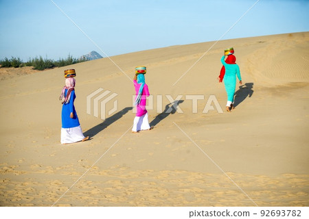 Art photo: the girls are walking in Nam Cuong sand dunes. 92693782