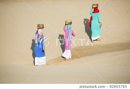 Art photo: the girls are walking in Nam Cuong sand dunes. 92693783