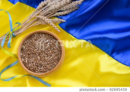 Fabric wave flag of Ukraine with wheat spikes. Blue and yellow bright colors Fabric wave flag of Ukraine with wheat spikes. Blue and yellow bright colors 92695439