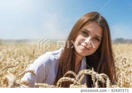 Young woman is posing in a wheat field closeup. Young woman is posing in a wheat field closeup. 92695571