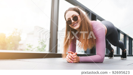 Fitness woman stands in plank while doing workout. 92695623