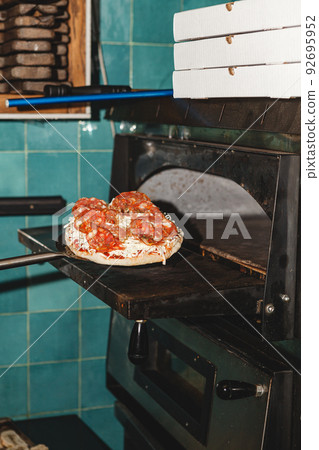 Pizza on the shoulder blade goes to the oven in the restaurant 92695952