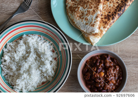 Chili con carne in a bowl accompanied by white rice and quesadillas Chili con carne in a bowl accompanied by white rice and quesadillas 92697606