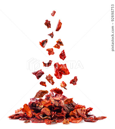 Dried red pepper falls on a pile close-up on a white background. Isolated 92698753