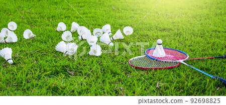 Shuttlecocks and badminton rackets on the green field Shuttlecocks and badminton rackets on the green field 92698825