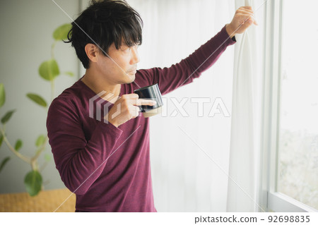 A man by the window 92698835