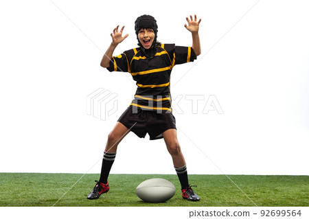 One sportive boy, kid, male rugby player training with ball isolated on white background with grass floooring. Sport, team, studying, skills concept One sportive boy, kid, male rugby player training with ball isolated on white background with grass floooring. Sport, team, studying, skills concept 92699564