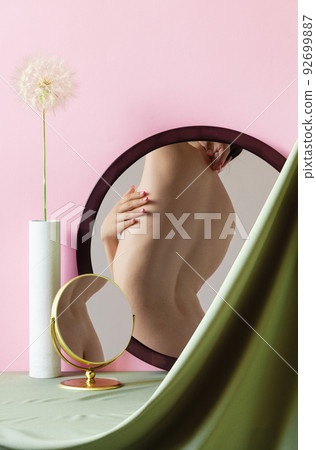 Tender shape. Female body on mirror reflection. Home interior background. Body art, aesthetics. Tender shape. Female body on mirror reflection. Home interior background. Body art, aesthetics. 92699887