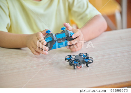 Elementary school boy operating a drone in the classroom 92699973