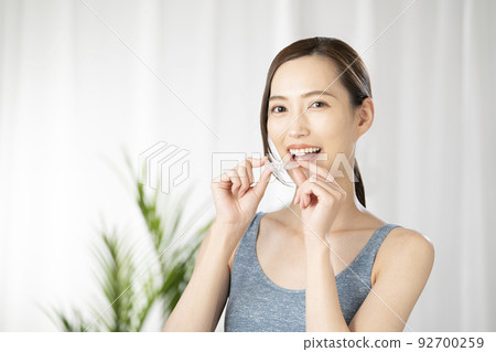 Woman holding a mouthpiece with both hands 92700259