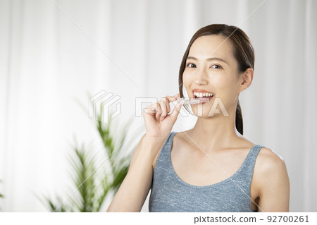 Woman holding a mouthpiece with one hand Woman holding a mouthpiece with one hand 92700261