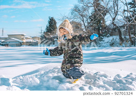 一個全神貫注在雪地裡玩耍的孩子 92701324