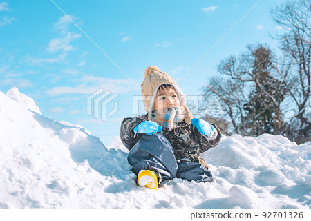 A child who is absorbed in playing in the snow 92701326