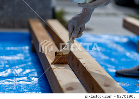 Do-it-yourself man painting pergola pillars Do-it-yourself man painting pergola pillars 92701903