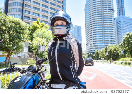 Smiling female rider touring Yokohama 92702377