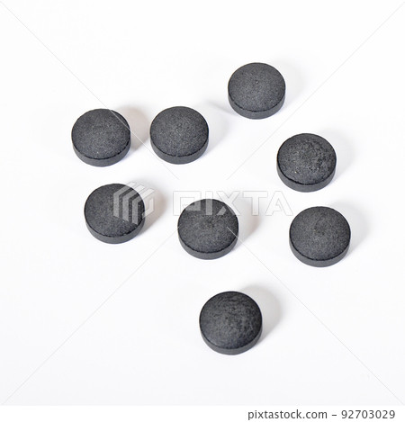 Activated charcoal round tablet pills isolated on white background Activated charcoal round tablet pills isolated on white background 92703029