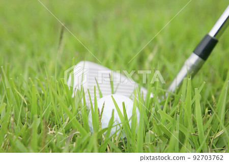 Golf ball and golf club on grass 92703762