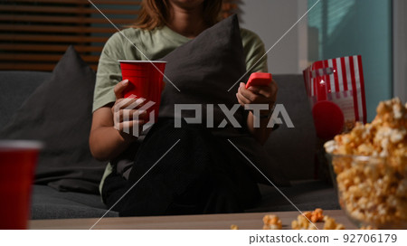 Young woman holding remote control, watching TV at home. Entertainment and leisure activity concept Young woman holding remote control, watching TV at home. Entertainment and leisure activity concept 92706179