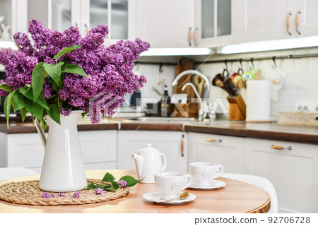 Bouquet of purple Lilac flowers in interior of the kitchen Bouquet of purple Lilac flowers in interior of the kitchen 92706728