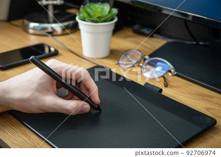 Man using graphic tablet for drawing Man using graphic tablet for drawing 92706974