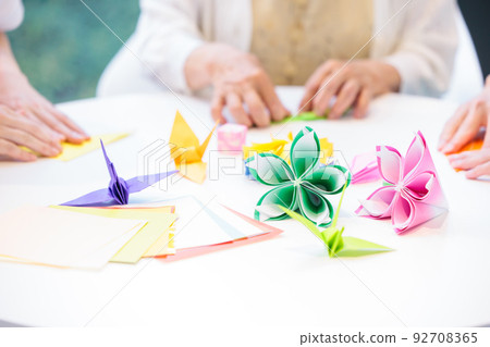 A senior woman folding origami and a caregiver Photography cooperation "LINK FOREST" 92708365