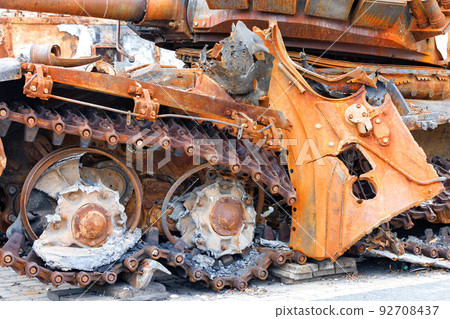 Torn caterpillars of a destroyed enemy rusty russian tank close-up. 92708437