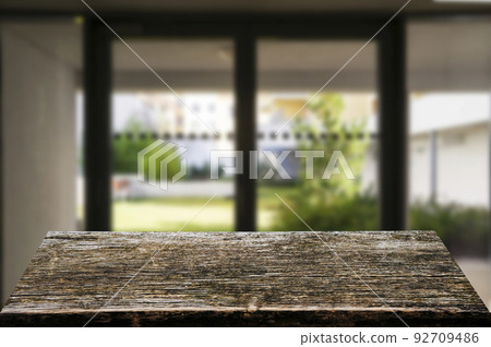Wooden brown table top against the blurred corridor, passage and courtyard of the house .For product display montage or design is the key visual of the layout. Wooden brown table top against the blurred corridor, passage and courtyard of the house .For product display montage or design is the key visual of the layout. 92709486