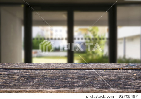 Wooden brown table top against the blurred corridor, passage and courtyard of the house .For product display montage or design is the key visual of the layout. Wooden brown table top against the blurred corridor, passage and courtyard of the house .For product display montage or design is the key visual of the layout. 92709487
