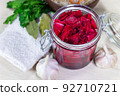 Healthy fermented canned cabbage sauerkraut with beetroot and herbs in a glass jar top view. 92710721