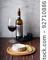 Still life of wine, cheese and grapes on wooden table. 92710886
