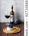 Cheese plate served with red wine and grape. Assorted cheeses Camembert and smoke cheese. 92710888