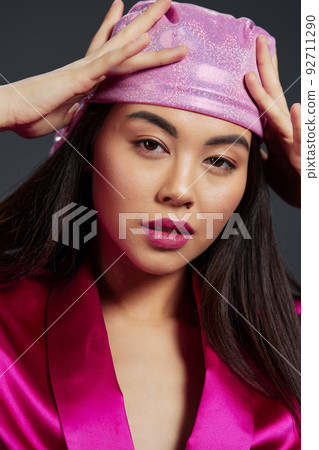 beautiful woman in a pink mini dress pink headscarf luxury close-up Gray background 92711290