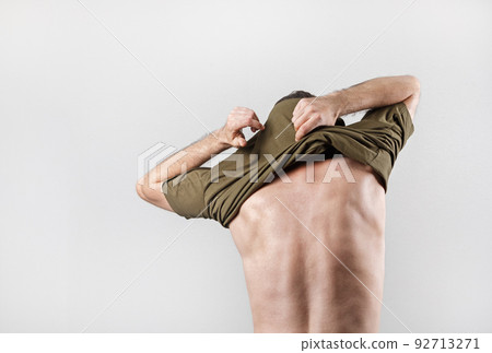 Man takes off t-shirt 92713271