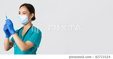 Covid-19, coronavirus disease, healthcare workers concept. Side view of confident smiling asian female physician, nurse prepare syringe with vaccine for flu shot, standing white background Covid-19, coronavirus disease, healthcare workers concept. Side view of confident smiling asian female physician, nurse prepare syringe with vaccine for flu shot, standing white background 92713324